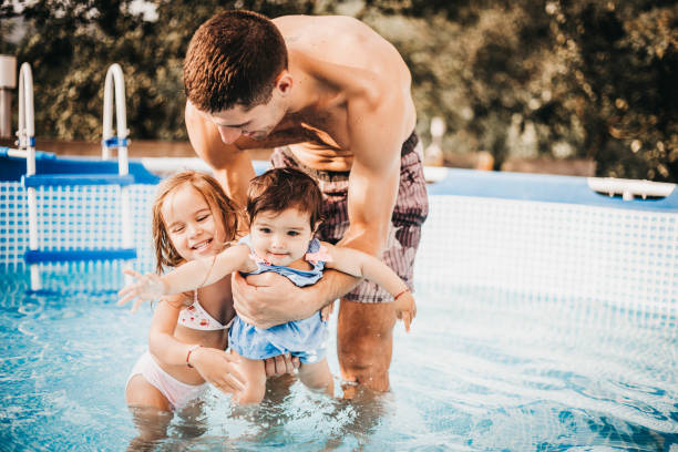 istock Dad and his two daughters in the pool 1011455232