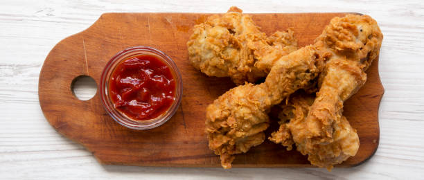 istock Fried chicken drumsticks with sauce on wooden board, top view. Overhead, flat lay, from above. 1011466332