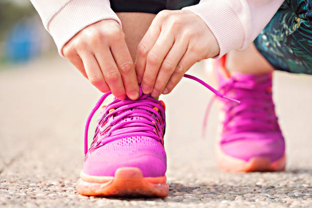 istock Young woman runner tying shoelaces 1011477454