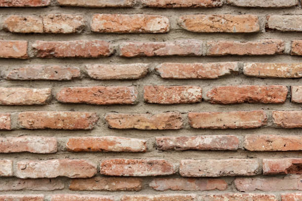 istock A dark red texture from an old brick wall. A destructive destruction of a brick wall. Brick background for text. 1011485536