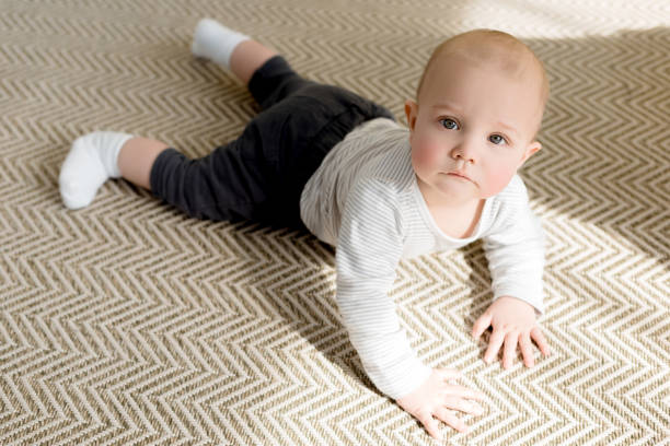 istock adorable little baby boy on floor looking at camera 1011494088