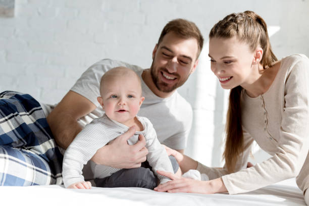 istock happy parents with little son on bed 1011494260