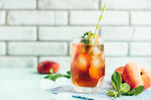 szklanka brzoskwiniowej herbaty lodowej na drewnianym stole. - ginger tea drink healthy eating zdjęcia i obrazy z banku zdjęć