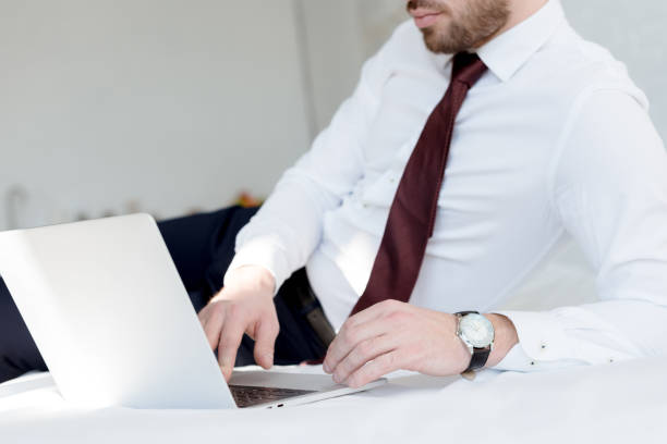 istock cropped view of businessman using laptop on bed 1011502216