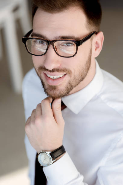 istock handsome smiling businessman in eyeglasses looking at camera 1011502304