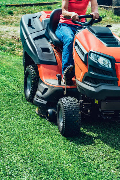 frau ausschnittgras mit einem reiten-auf rasenmäher - lawn mower tractor gardening riding mower stock-fotos und bilder
