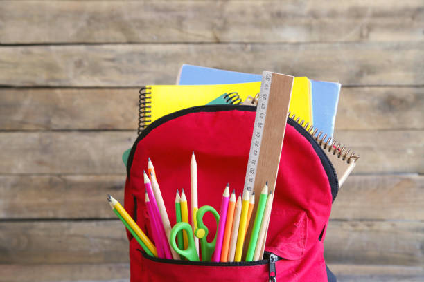istock Backpack with school supplies on wooden table 1011505752