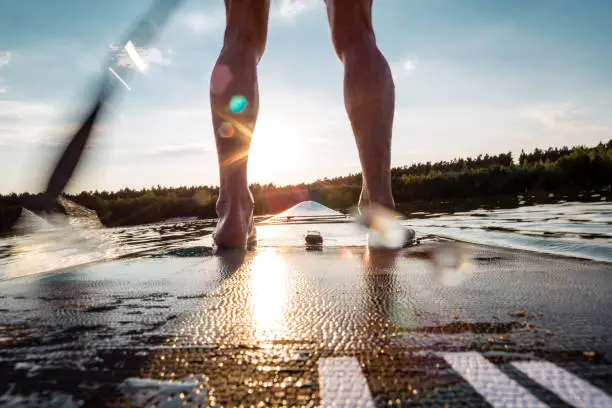 Stand Up Paddling at sunset - motion blur