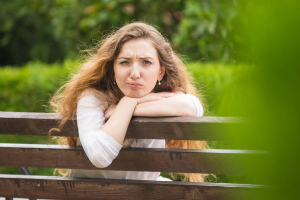 istock A young girl sitting on a bench turned and looked ridiculously into the frame 1011507070