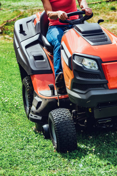 istock Woman cutting grass with a ride-on lawnmower 1011513996