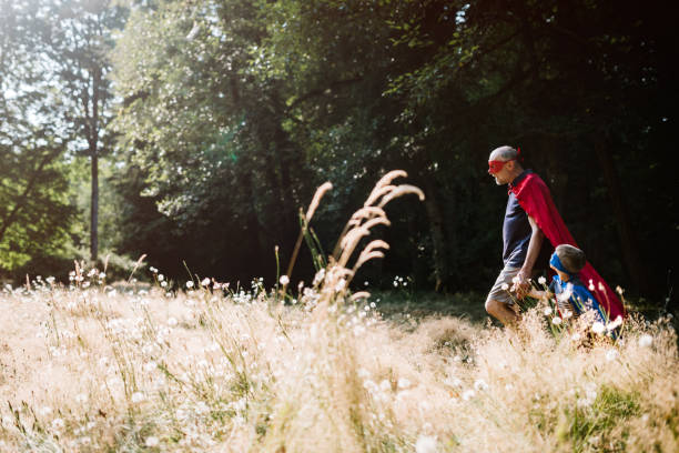 istock Grandfather Dressed As Superhero Plays Outside With Grandson 1011514228
