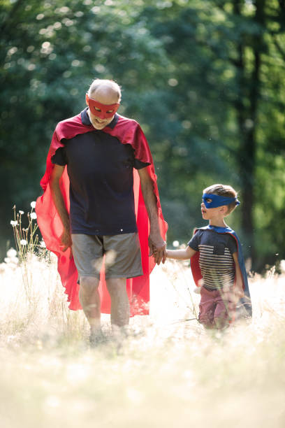 istock Grandfather Dressed As Superhero Plays Outside With Grandson 1011514434