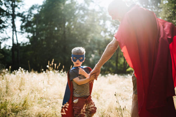 istock Grandfather Dressed As Superhero Plays Outside With Grandson 1011514556