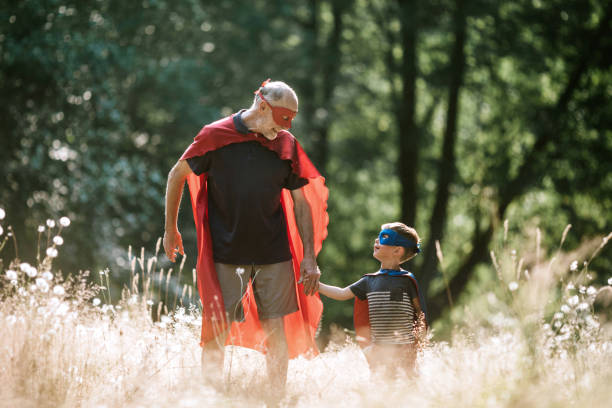 istock Grandfather Dressed As Superhero Plays Outside With Grandson 1011514604