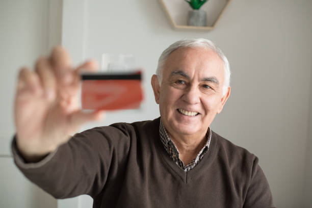 istock Senior man holding credit card and smiling 1011533784