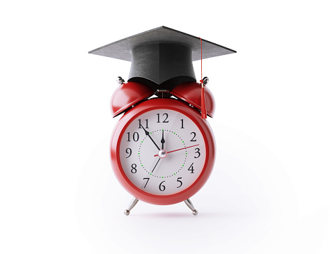 Red alarm clock wearing a graduation cap on white background. Horizontal composition clipping path and copy space.