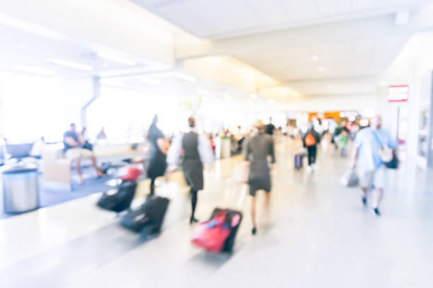 istock Motion blurred flight attendants walking with suitcase at American airport 1011542664