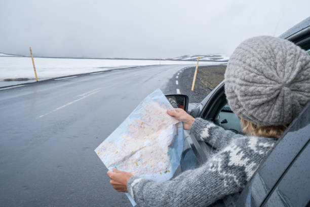 istock Girl in car looking at map, road trip concept vacations 1011553420