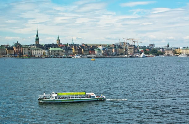 STOCKHOLM, SWEDEN - JULY 11, 2018: Boats for sightseeing and ferry for long distance travel in front of Stockholm skyline at Stadsgardskajen on July 11, 2018 in Stockholm, Sweden.