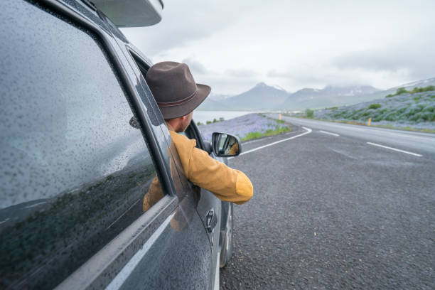 istock Young man in car looking outside window, road trip concept vacations 1011556006