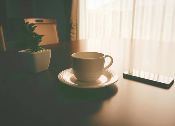 istock coffee cup and smartphone on desk with sunlight from the windows 1011586990