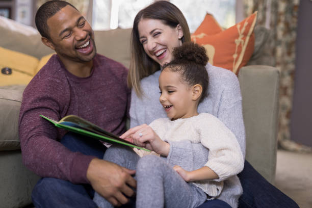 istock Mixed race family reading a book together 1011594960