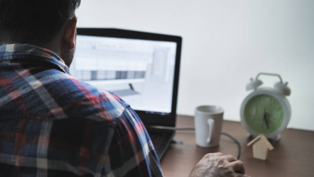 vista trasera del arquitecto hombre trabajo en casa en portátil, diseñador dibujar dibujo proyecto construcción de casa de diseño de bosquejo proyecto de trabajo - drafter fotografías e imágenes de stock