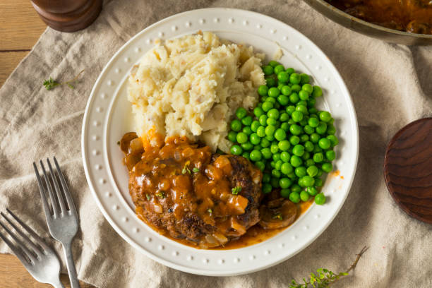 Homemade Savory Salisbury Steaks Homemade Savory Salisbury Steaks with Peas and Mashed Potatoes salisbury steak stock pictures, royalty-free photos & images