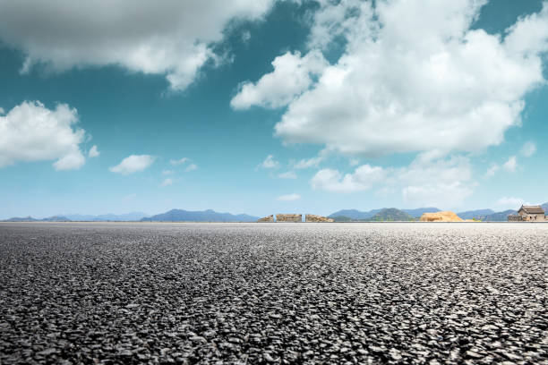 istock Asphalt road and great wall with mountains under the blue sky 1011616406