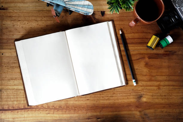 istock Open blank white notebook on artist wooden table and supplies. 1011626520