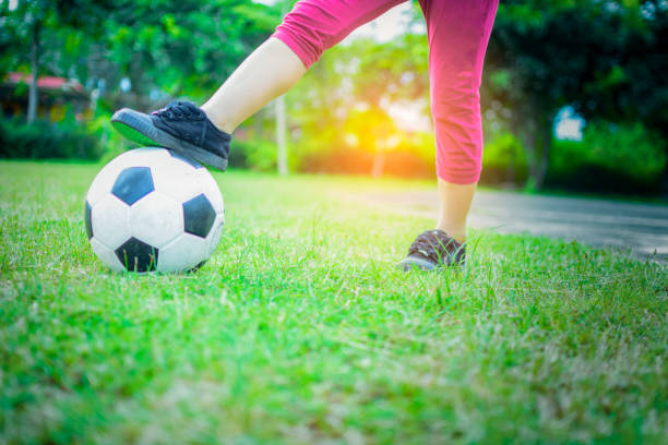 istock Boy  with ball on green grass with sunshine background. 1011640434