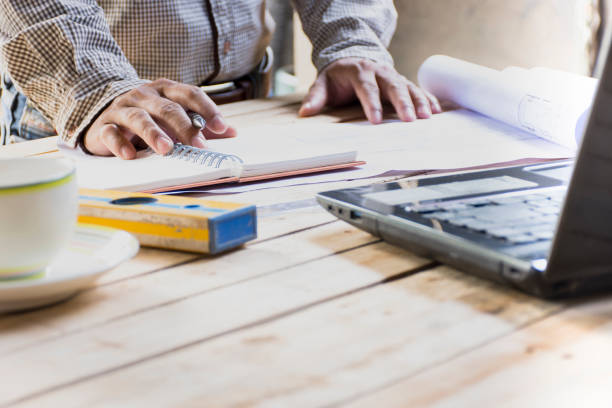 istock Man architect working with equipment on wooden table.Zoom in 1011640442