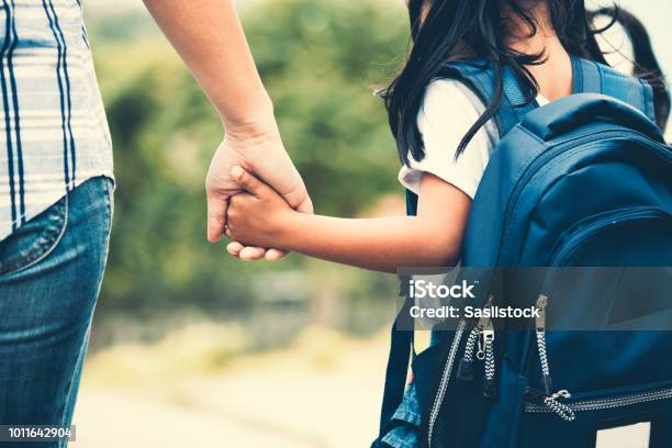 Foto de Menina Bonito Aluno Asiáticos Com Mochila Segurando A Mão Da Mãe Dela E Indo Para A Escola e mais fotos de stock de Criança