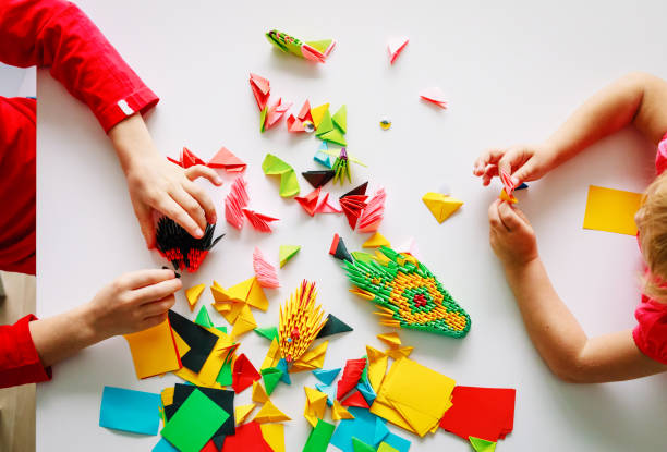 istock kids making origami crafts with paper 1011645472