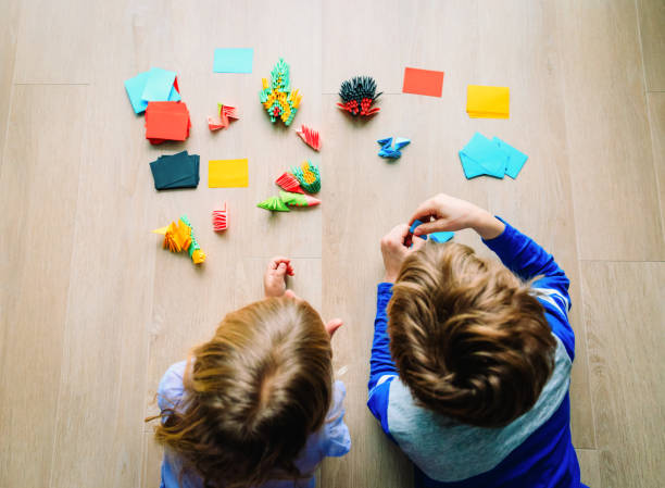 istock kids making origami crafts with paper 1011645772