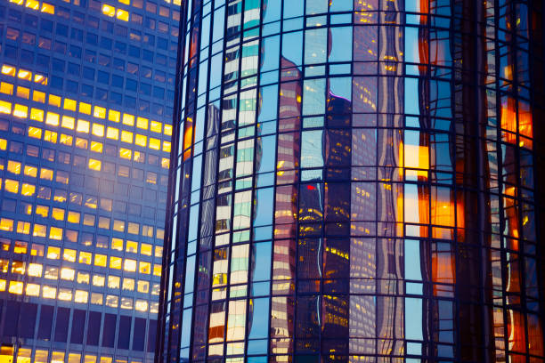 immeuble de bureaux lumineux la nuit - night cityscape reflection usa photos et images de collection