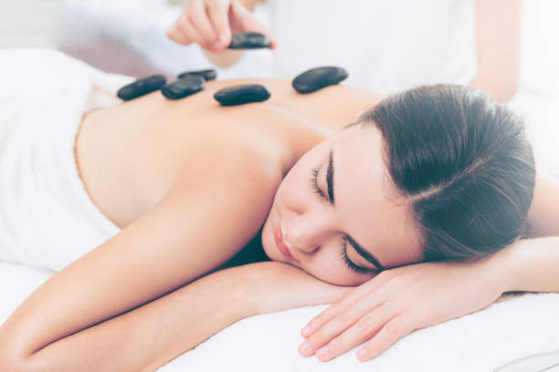 istock Hot stone massage treatment by therapist in spa. 1011654008