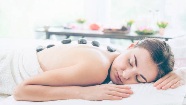 istock Hot stone massage treatment by therapist in spa. 1011654096