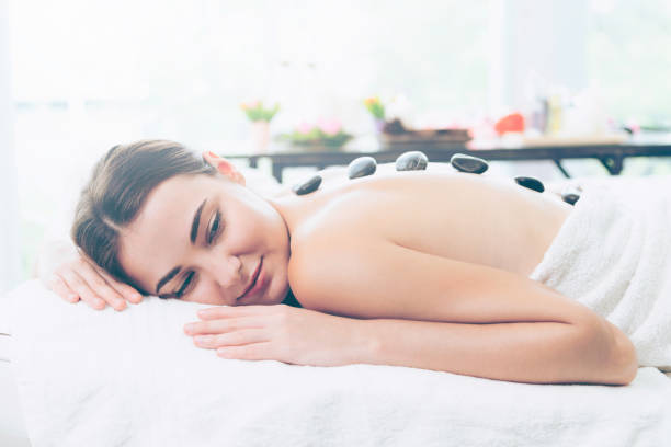 istock Hot stone massage treatment by therapist in spa. 1011654116