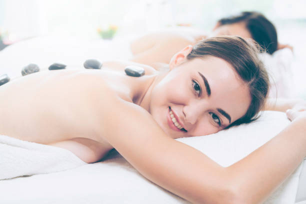 istock Hot stone massage treatment by therapist in spa. 1011654296