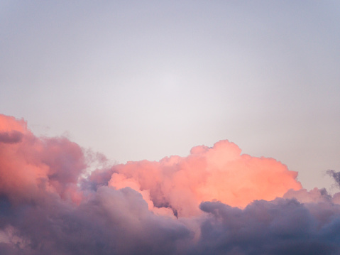 Gorgeous close up view of fluffy cumulus clouds with pink and purple hues resembling delicious mouthwatering cotton candy.