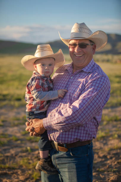 istock Cowboy grandpa with grandson on a field 1011667794