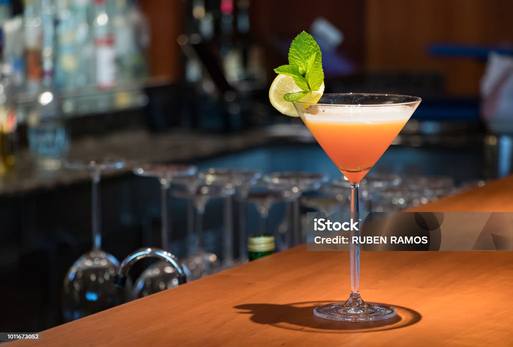 Un verre de Martini de couleur orange sur le comptoir en bois. - Photo de Martini dry libre de droits