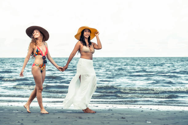istock Happy women go sunbathing at sand beach in summer. 1011673082