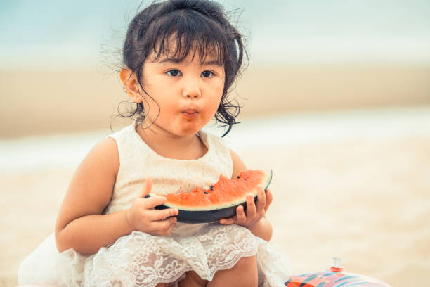 istock Adorable kid eating watermelon on the beach. 1011673154