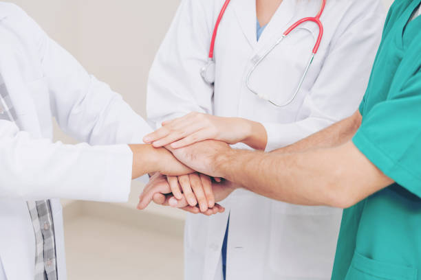istock Doctor, surgeon and nurse join hands together. 1011675552