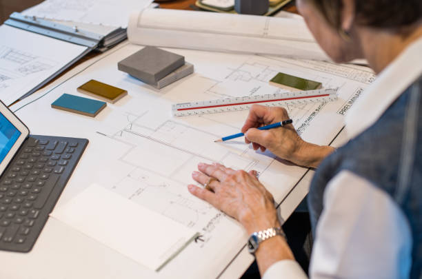 istock Senior woman working in interior design office working on plans 1011683062