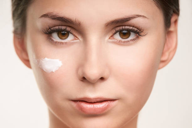 istock SPF factor cosmetic cream on face. UV care beautiful girl face 1011709094