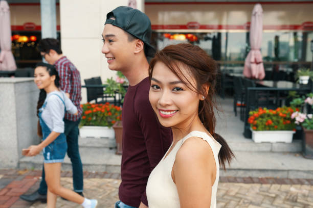 Attractive Vietnamese woman walking in the street with her boyfriend