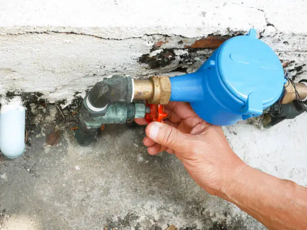 Photo of Hand opening water valve by turning handle
